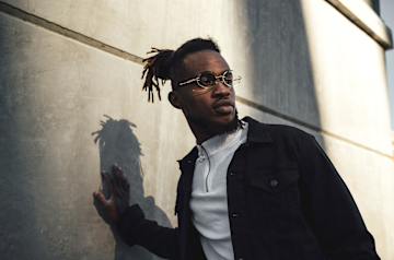 Man leaning on wall with glasses